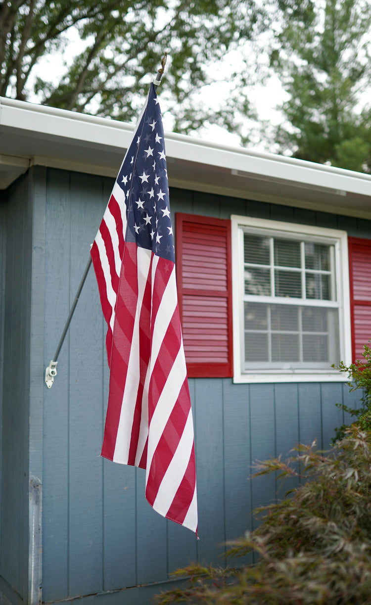 A porch flag and pole set with an American flag.